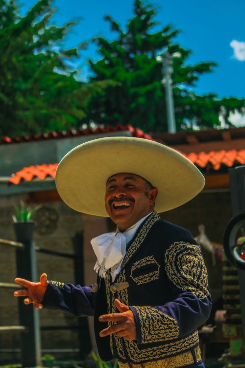 Free Cheerful man in Mexican charro suit with sombrero enjoying outdoors. Stock Photo
