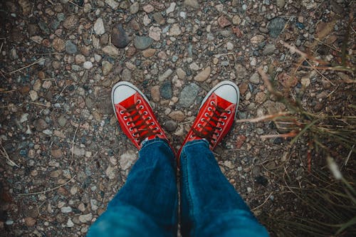 Person in Jeans and Red Shoes