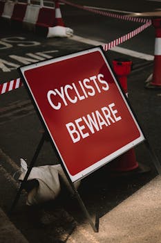 Red warning sign for cyclists on a city street in London, cautioning urban road users.