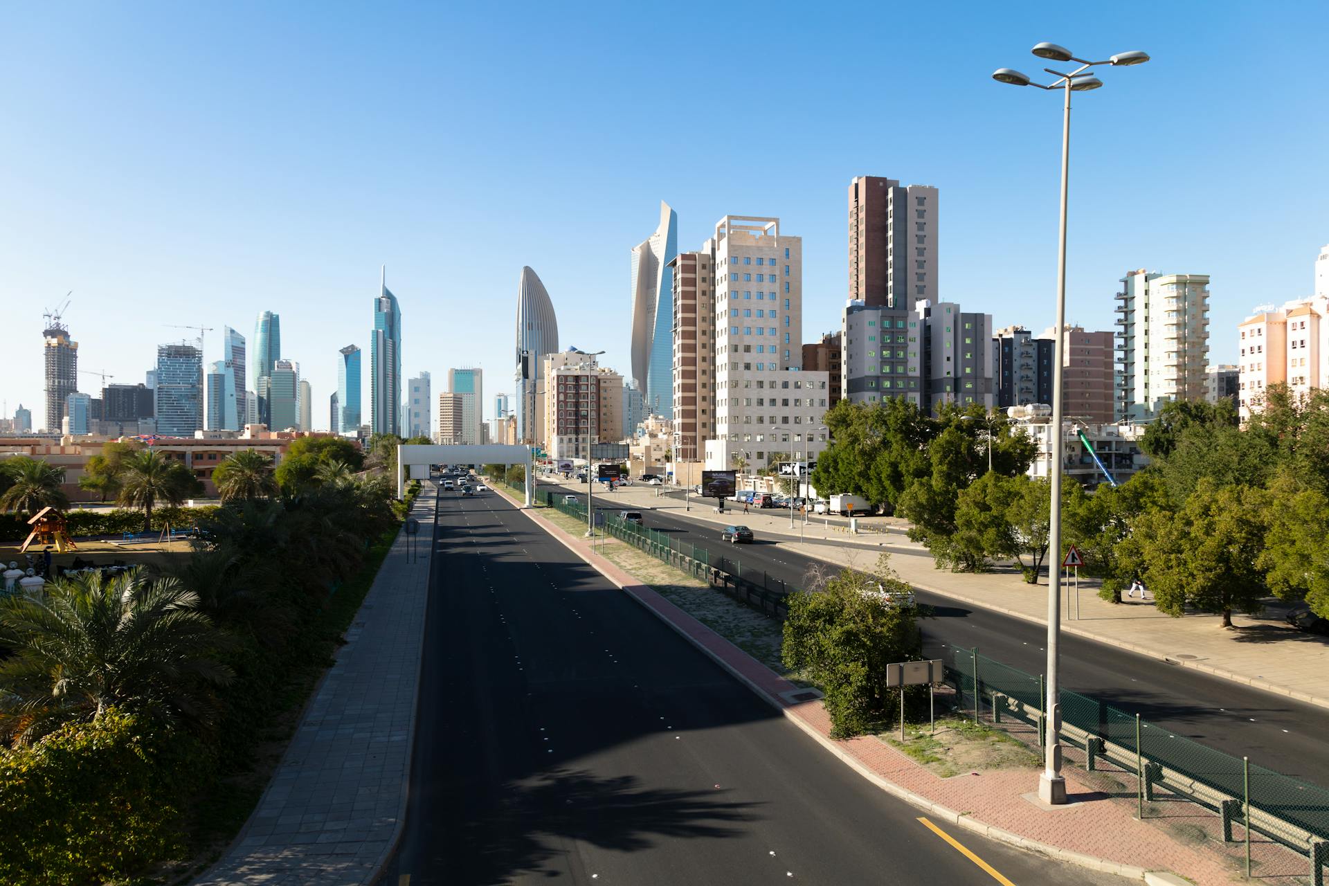 Aerial view of modern skyscrapers in Kuwait City under a clear blue sky.