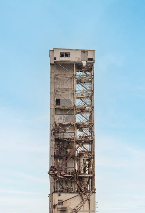 Rusty Conveyor Tower for Unloading Ships Against the Blue Sky