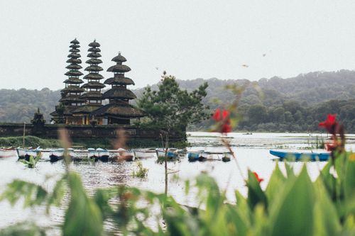 Free Beautiful scene of Ulun Danu Bratan Temple in Bali with serene lake and traditional boats. Stock Photo