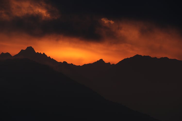 Clouds Over Mountains Silhouette At Sunset