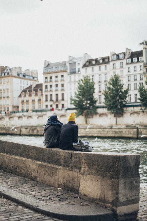 Free Man and Woman Sitting by the River Stock Photo