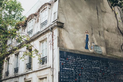 Free Captivating graffiti mural on an ivy-covered urban building, blending nature and art. Stock Photo