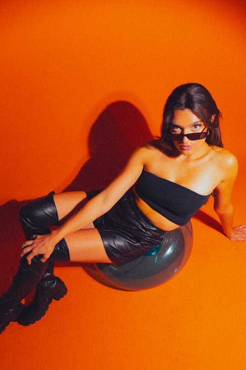 Studio Shot of a Young Fashionable Woman in a Black Outfit and Sunglasses