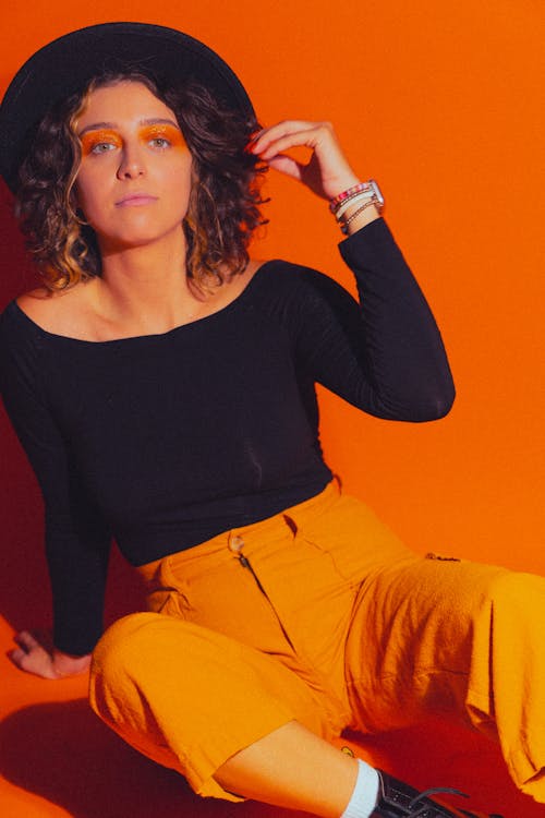 Young Woman in a Black Hat and Orange Pants 