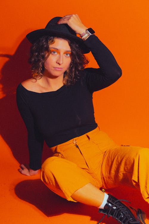 A Woman in a Hat on Orange Background