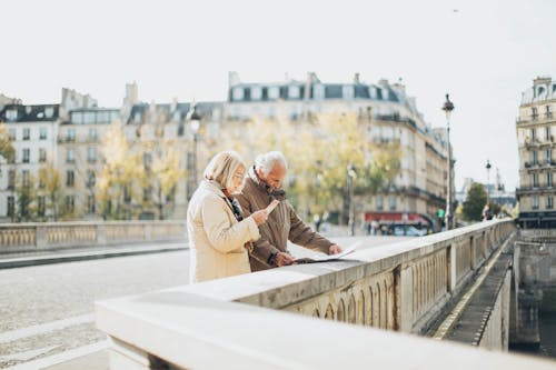 Free Man and Woman Standing Near the Road While Reading Stock Photo