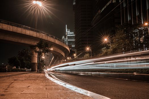 Long-exposure capture of a city's illuminated expressway at night, showing motion blur from passing cars.