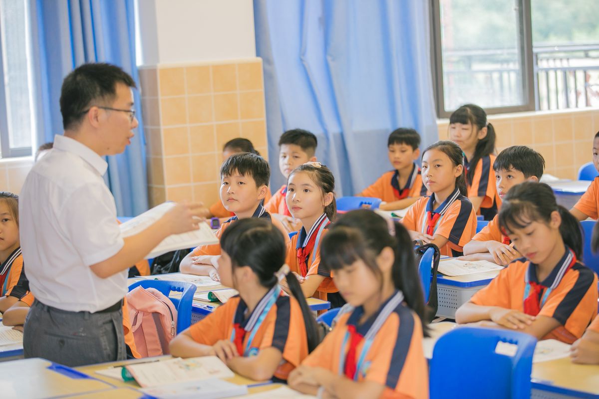 Asian teacher conducting lesson with attentive students in bright classroom