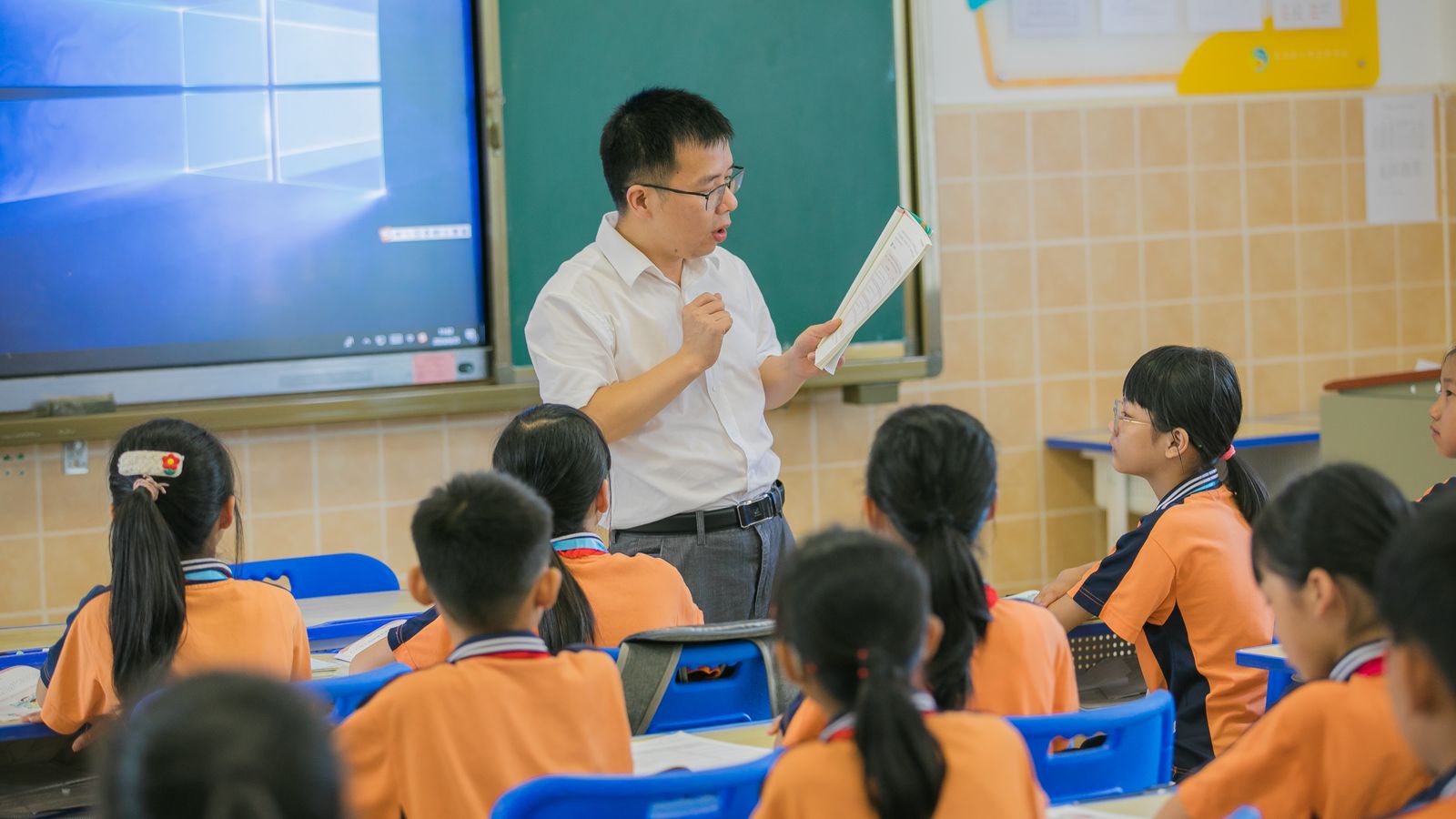 Teacher and young students working together in a classroom during a teaching English to young learners lesson