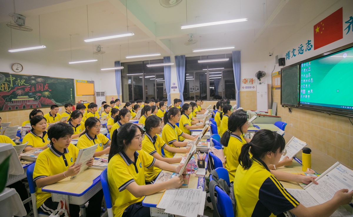 Asian students in classroom engaged in learning with teacher focusing on education