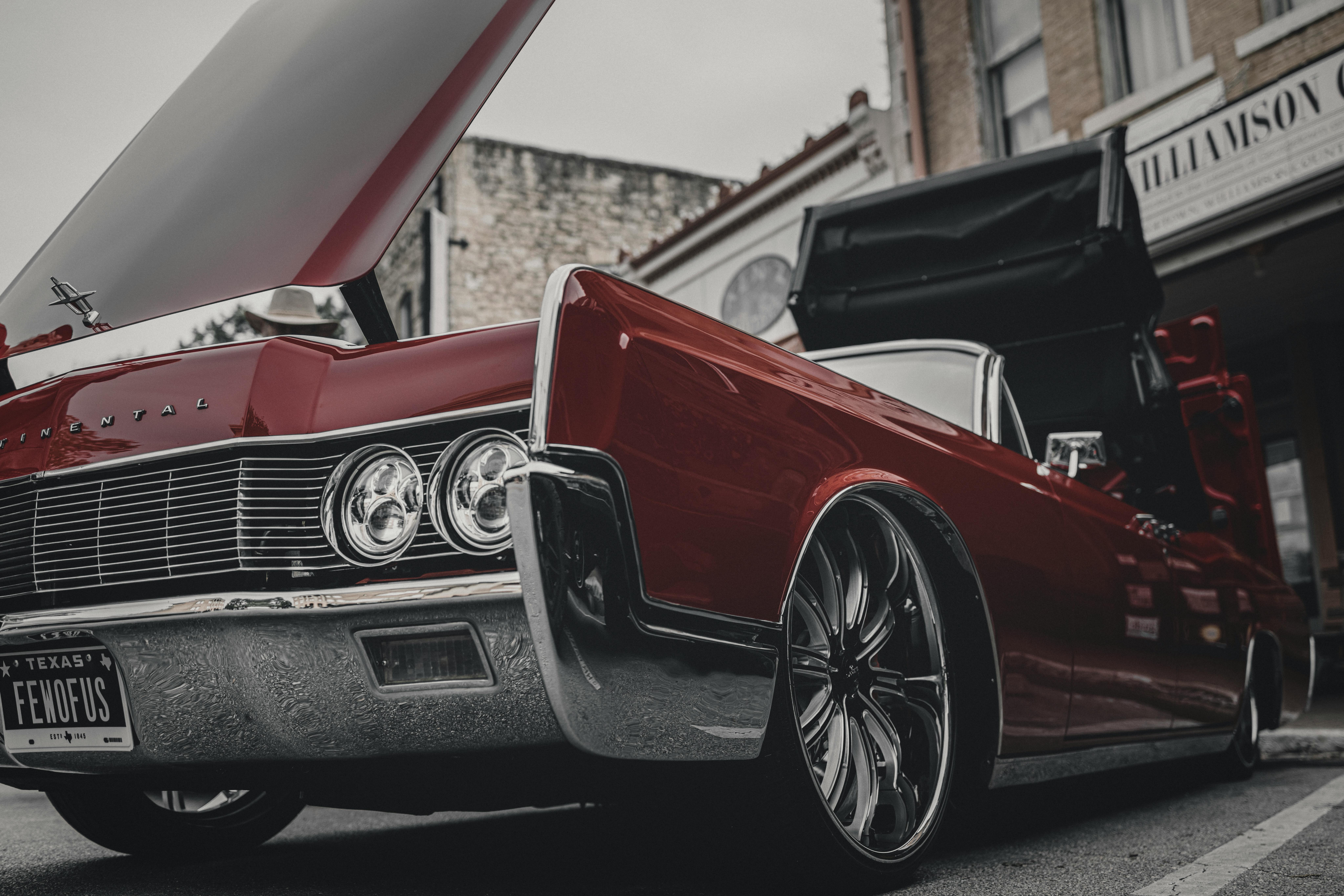 A sleek red Continental car with an open hood captured in urban Georgetown, Texas.