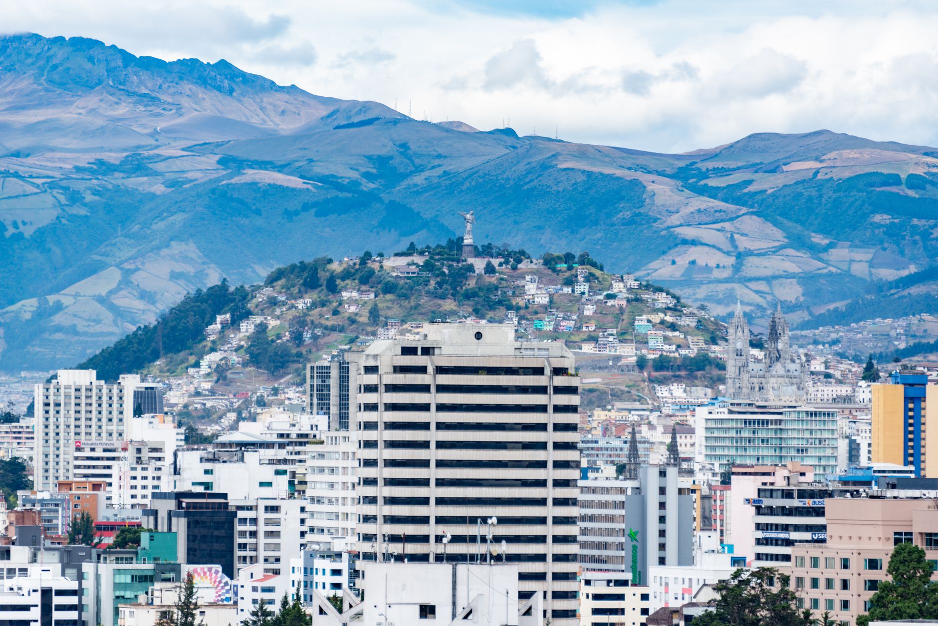 Aerial view of Quito with city buildings and the majestic Andes in the background