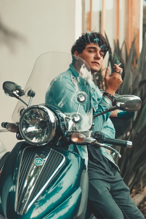무료 흡연하는 동안 녹색 오토바이에 앉아 남자 스톡 사진