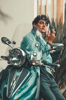 在巴西圣保罗一个阳光明媚的日子里，一名穿着牛仔夹克的时尚男子骑着摩托车摆姿势