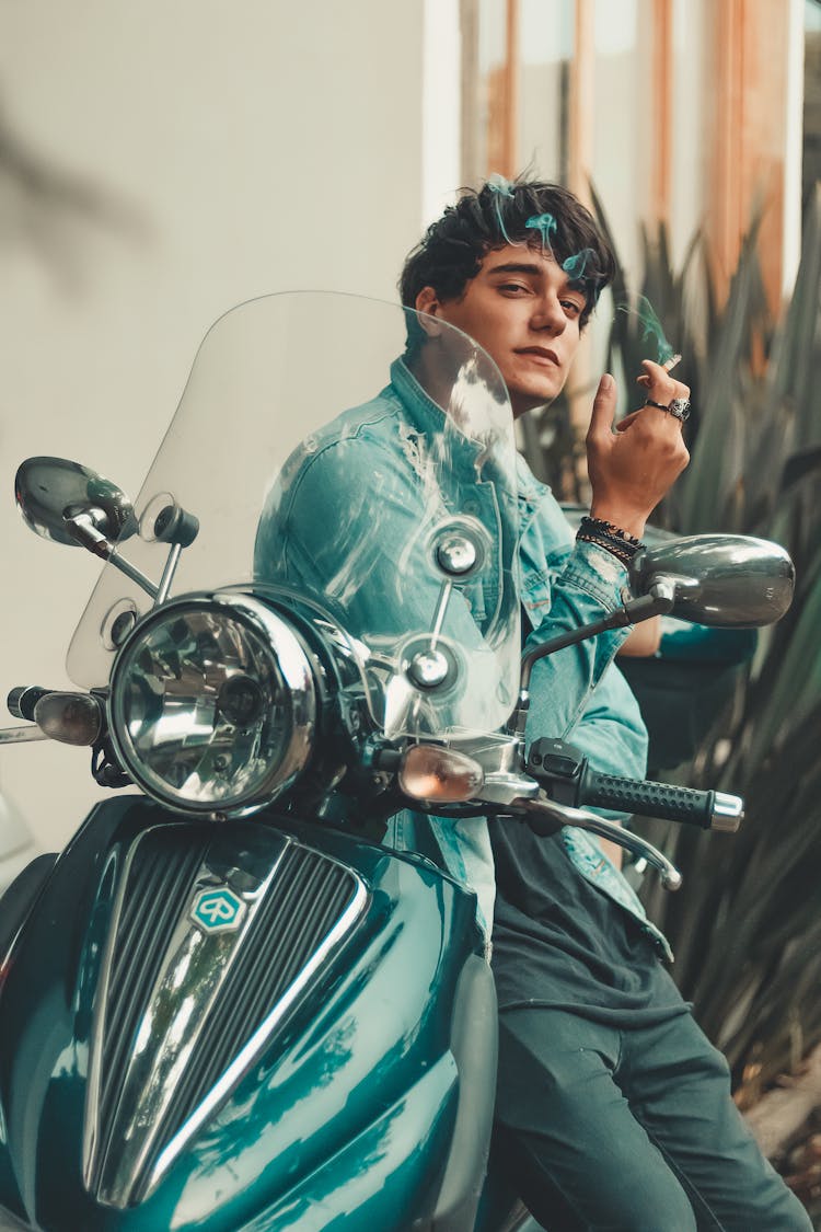 Man Sitting On Green Motorcycle While Smoking