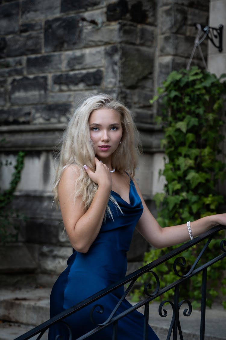 Blonde Woman In A Dress Walking On A Staircase