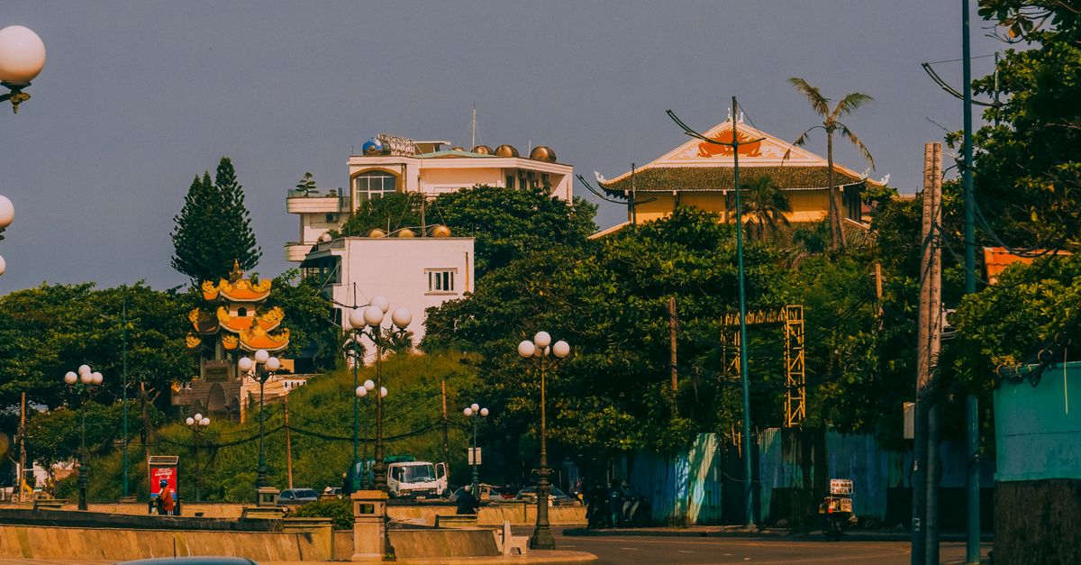 Peaceful city street with parked car and buildings under clear sky.