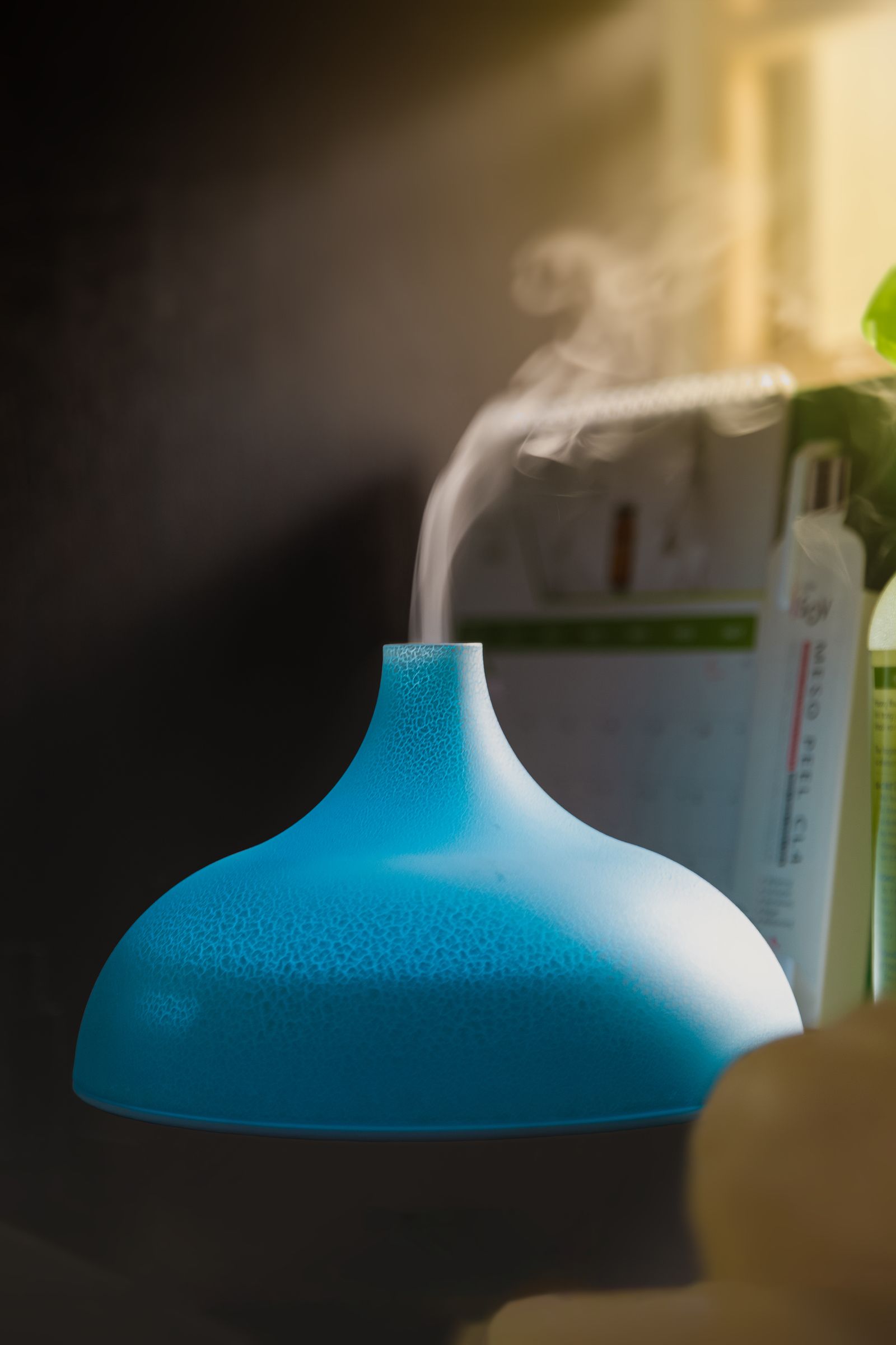 Close-up of fine cool mist rising from a humidifier in a softly lit room