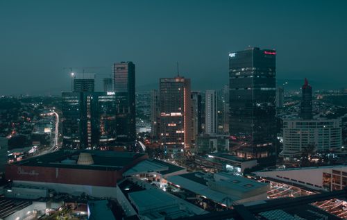 Free Stunning aerial night view of illuminated modern buildings in a bustling city. Stock Photo