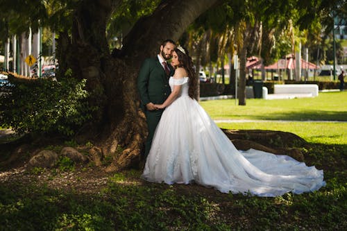 Newlyweds Posing by Tree in Park