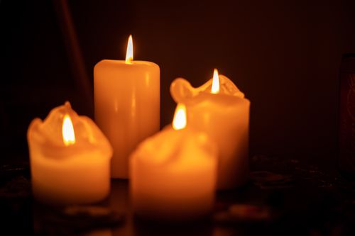 Free Warm and soothing close-up of burning wax candles on a dark background, creating a serene atmosphere. Stock Photo