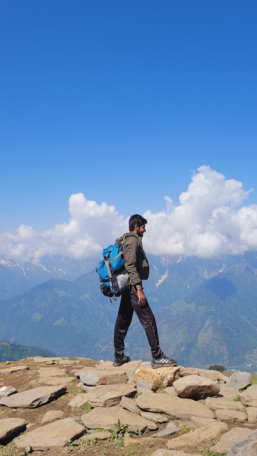 Man with a Backpack Standing at the Mountain Peak 