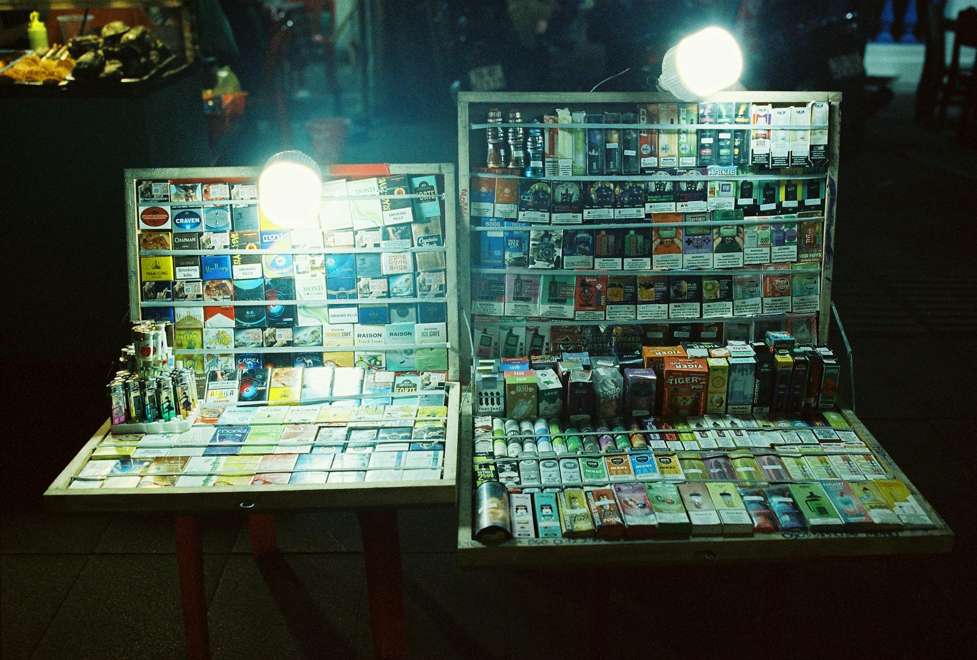 Illuminated tobacco products on display at a night market stall in Ho Chi Minh City.