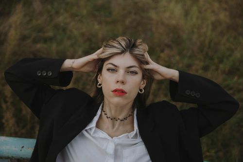 Free Stylish woman in black blazer with red lipstick posing confidently outdoors in Berlin. Stock Photo