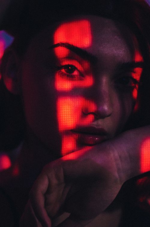 Free A pensive woman with striking light patterns creating a moody effect in Baku, Azerbaijan. Stock Photo