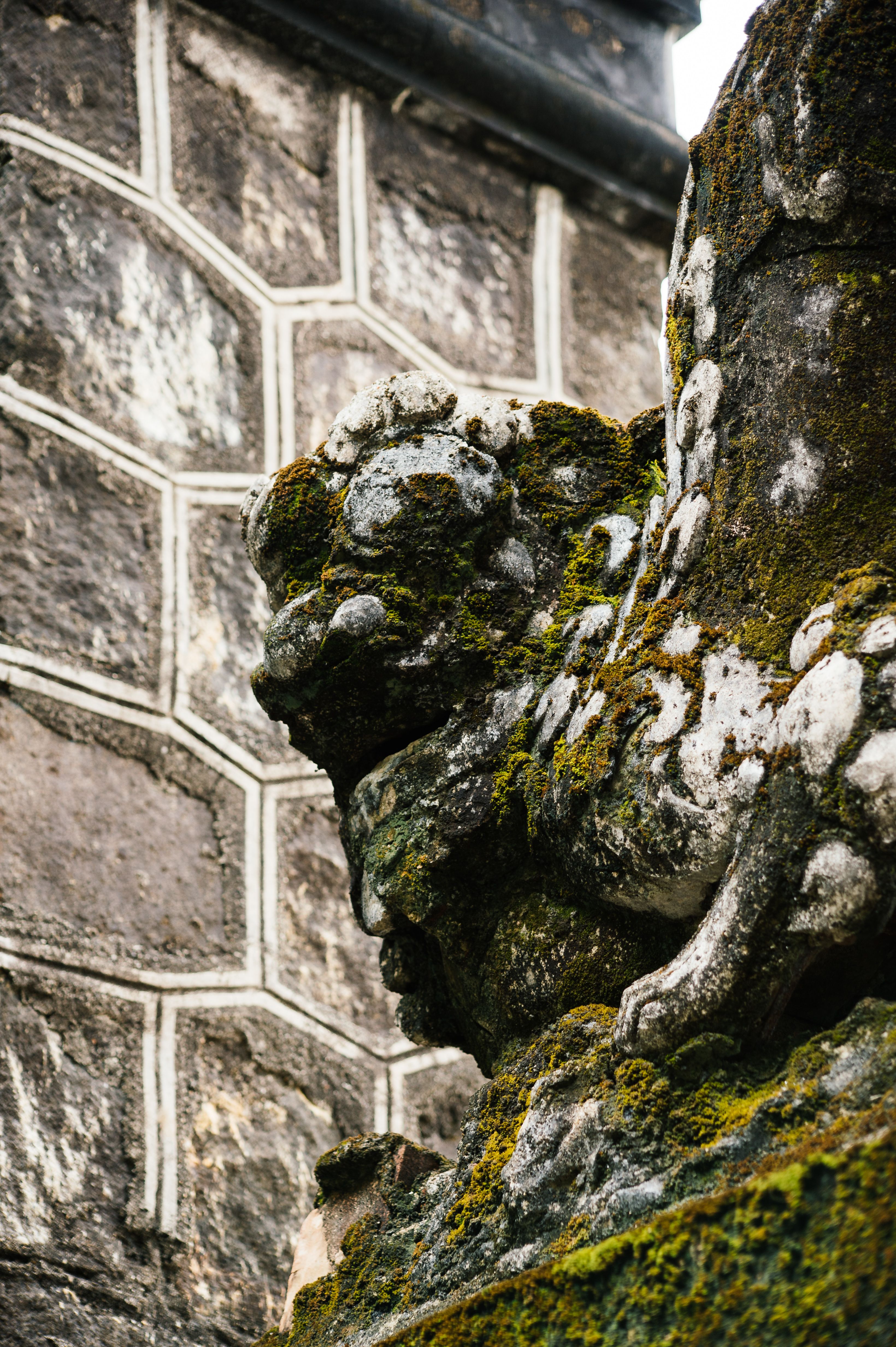 Close-up of a mossy stone statue at Tu Hieu Pagoda in Hue, Vietnam.