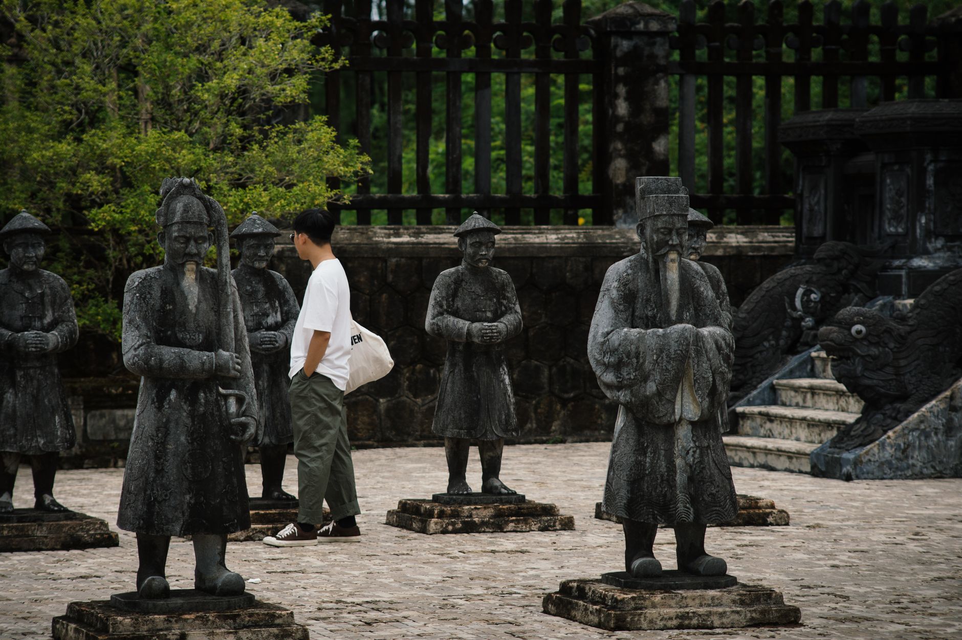 Tourist walking among sculptures at Khai Dinh Mausoleum in Vietnam, a UNESCO World Heritage Site.