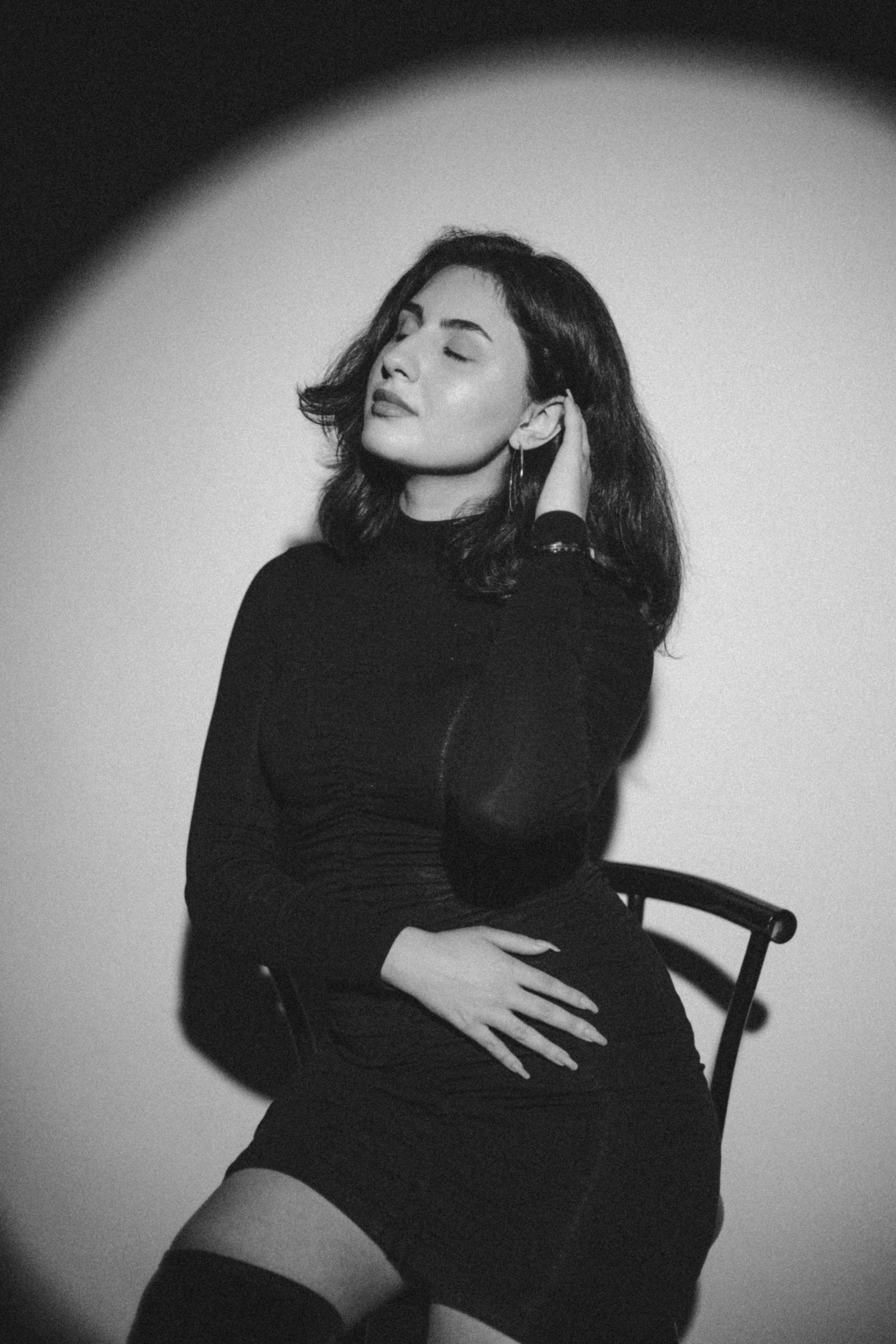 A woman in a black dress sitting on a chair · Free Stock Photo