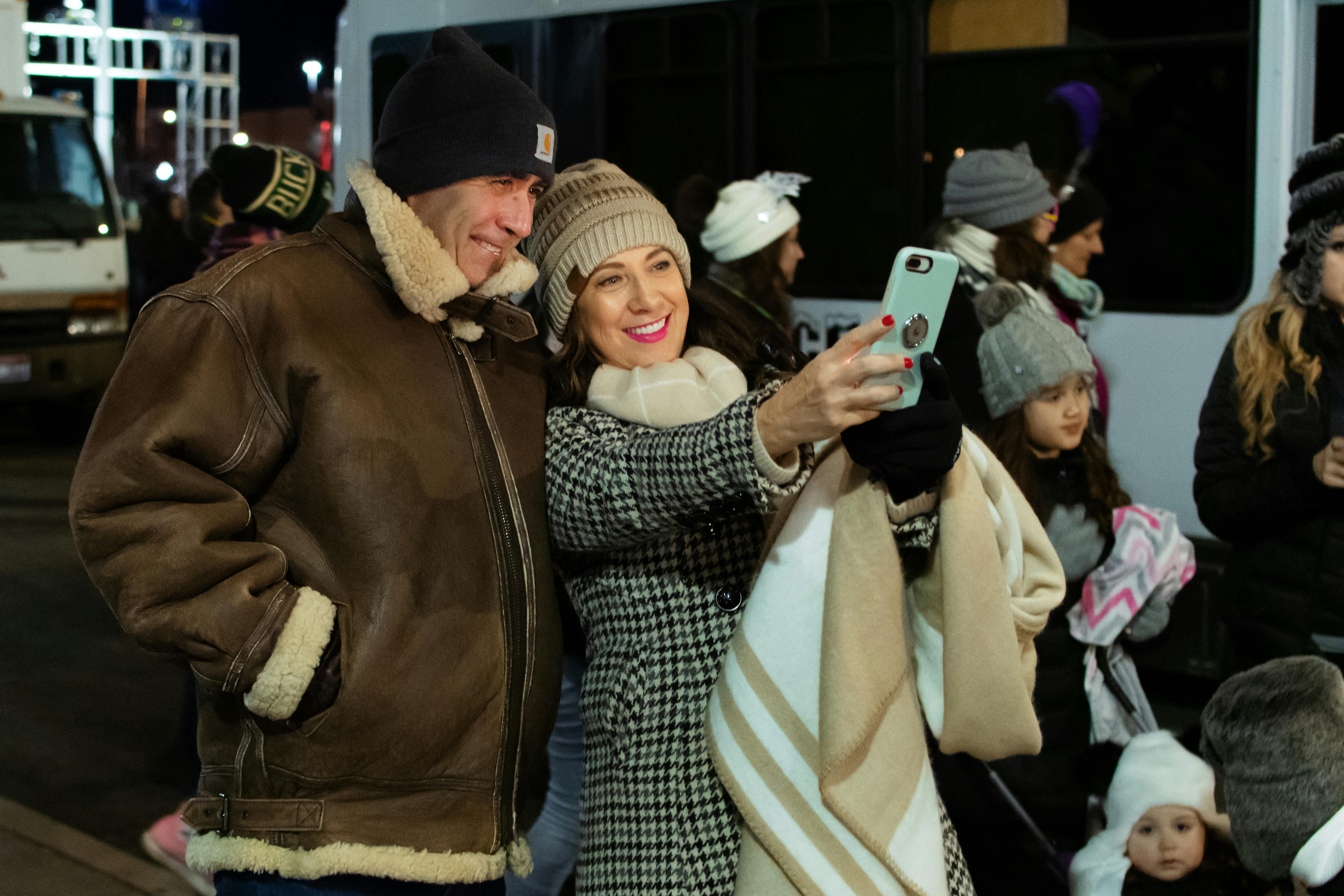 Couple souriant prenant un selfie amusant lors d'un événement, illustrant la joie et les souvenirs créés par les animations photo.
