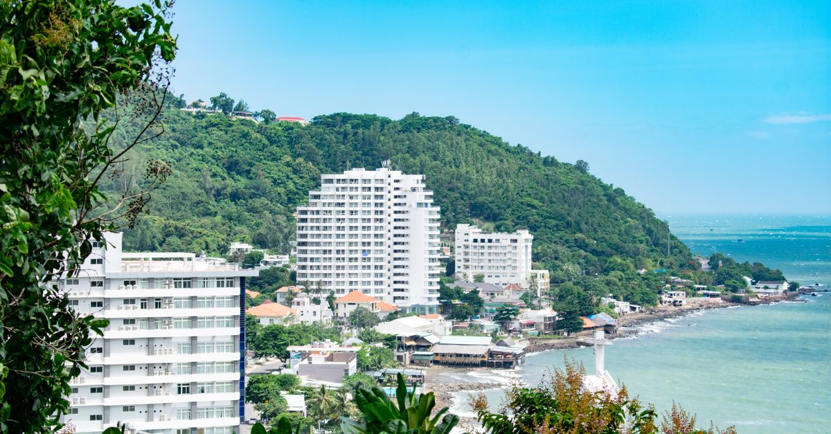 Scenic view of Vũng Tàu's coast with modern buildings and lush green hills.