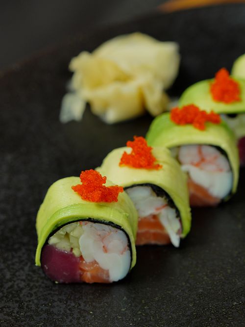 Free Delicious sushi roll with avocado and fish roe topping, beautifully presented. Stock Photo