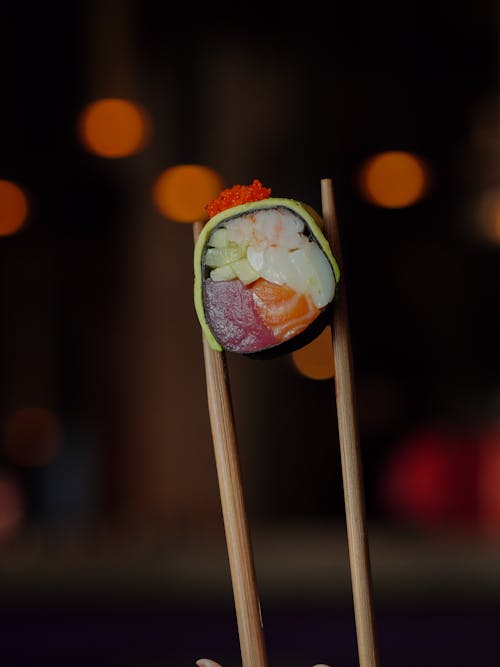 A Piece of Sushi Held in Chopsticks