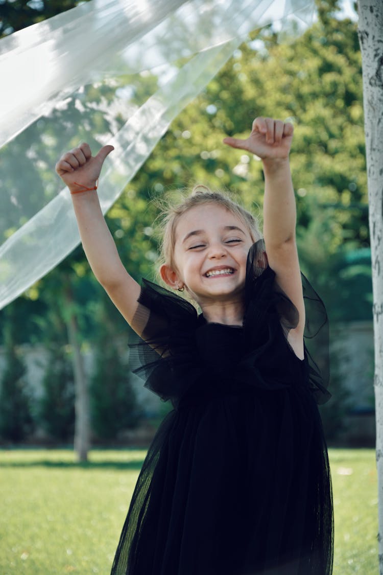 A Little Girl In A Black Tulle Dress In The Park