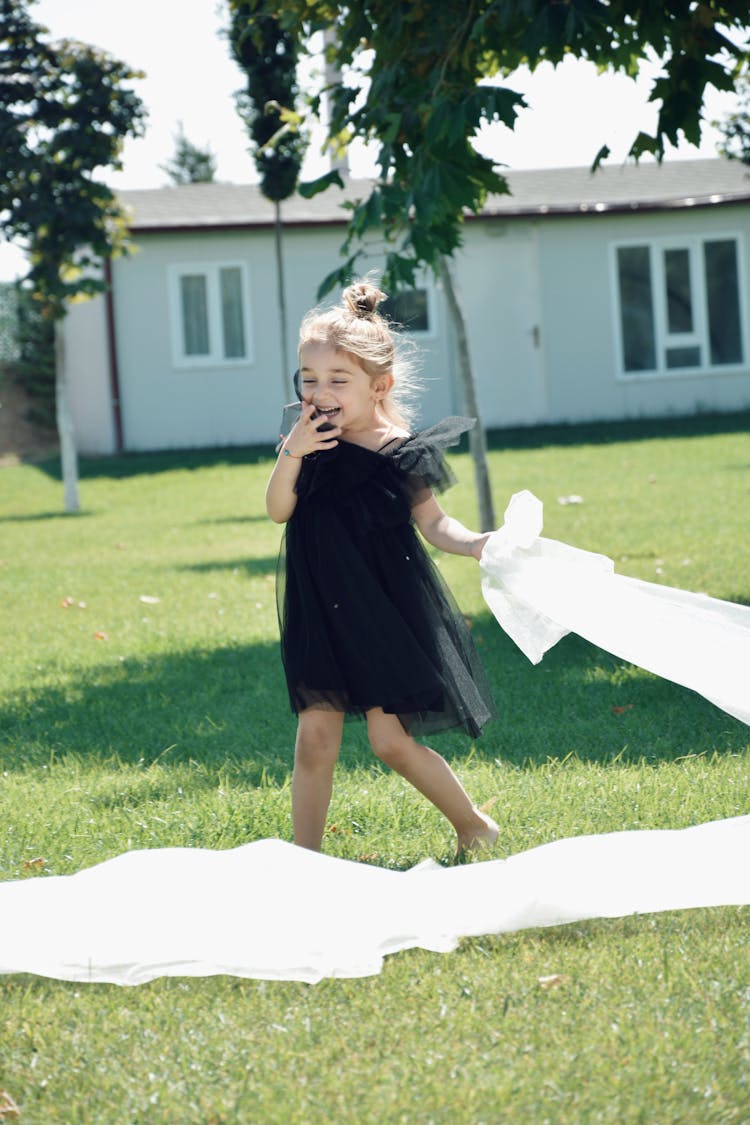 A Little Girl In A Black Tulle Dress In The Park