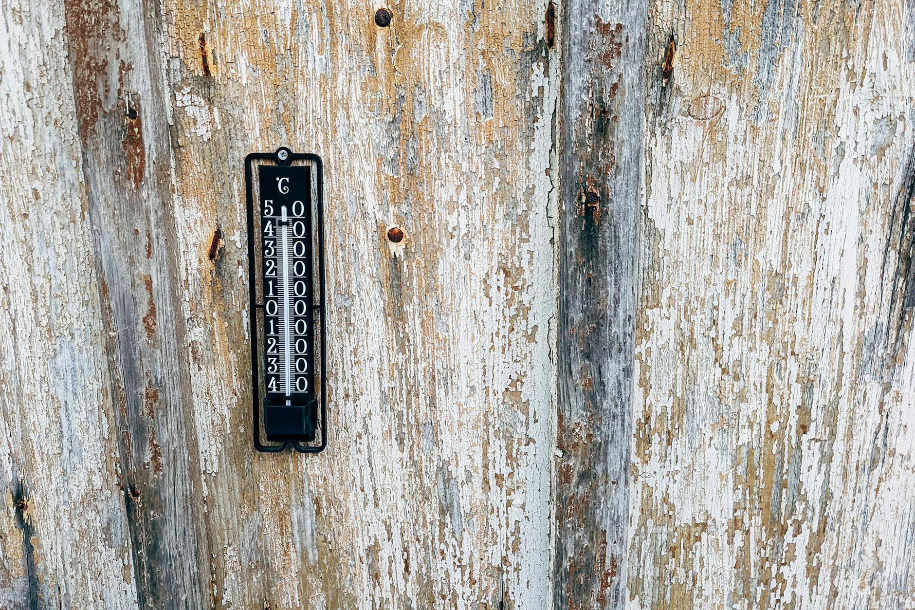 A thermometer on a wooden wall