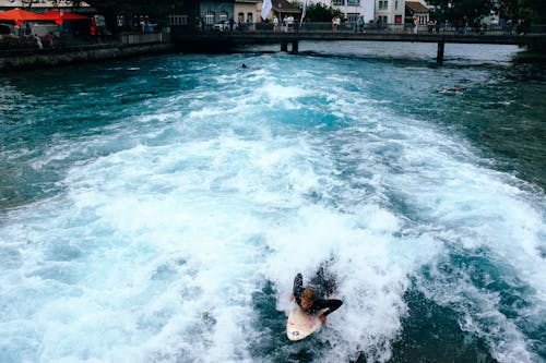 Man Surfing in the Canal in City 