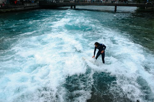 Man Surfing in the Canal in City 