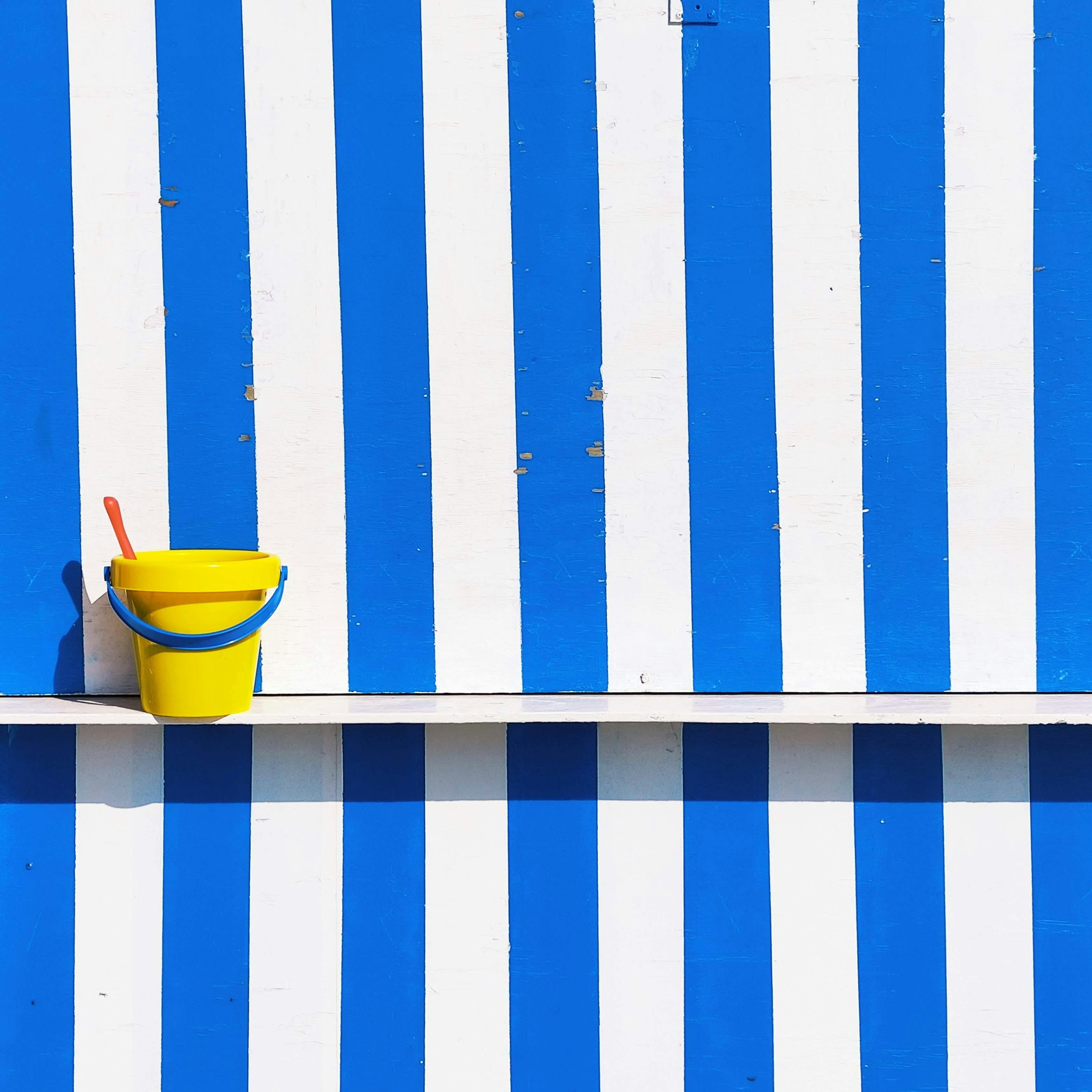 toy bucket and shovel on the wall with white and blue stripes