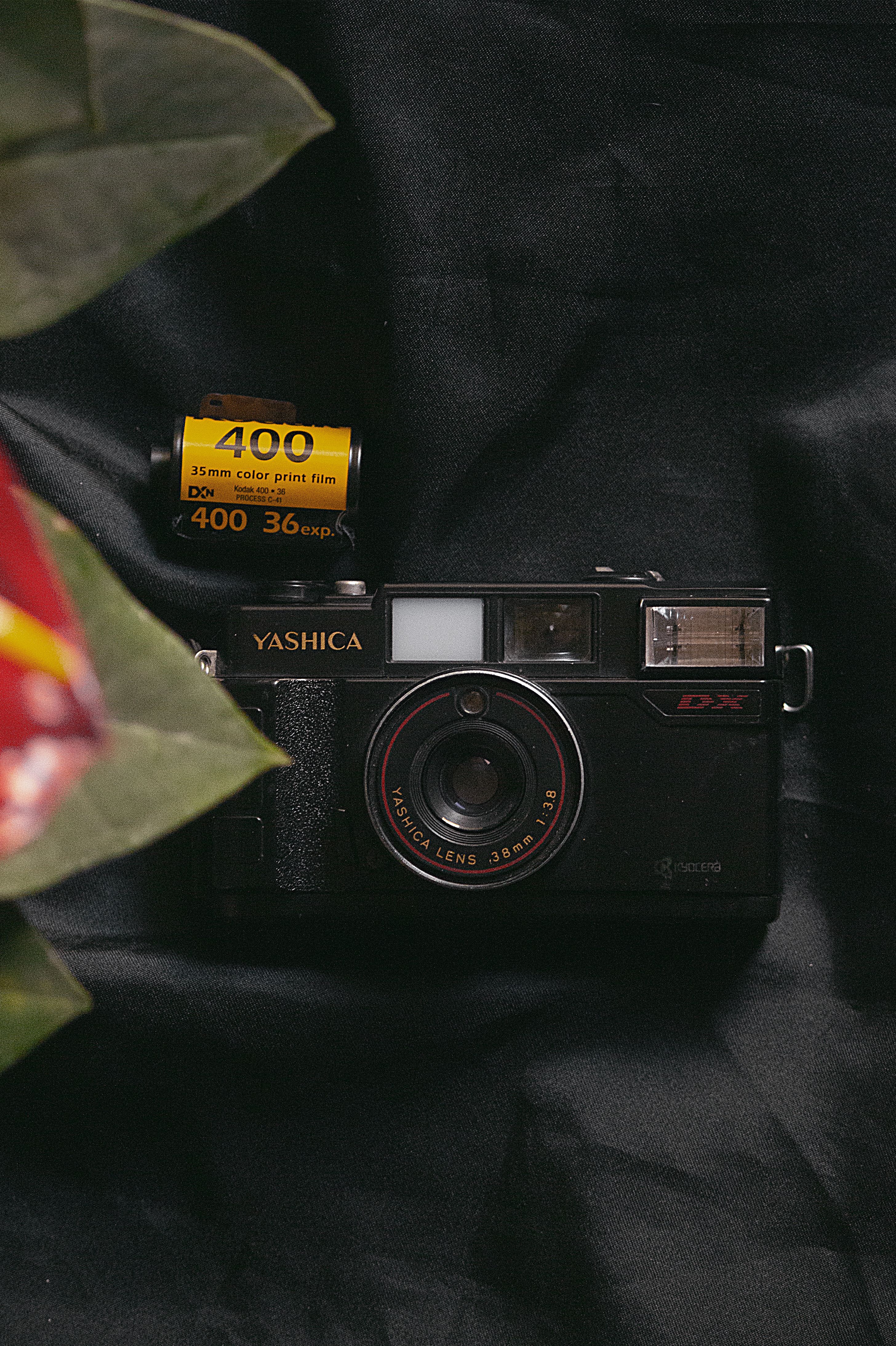 Close-up of a retro Yashica camera with 35mm film on dark fabric background.