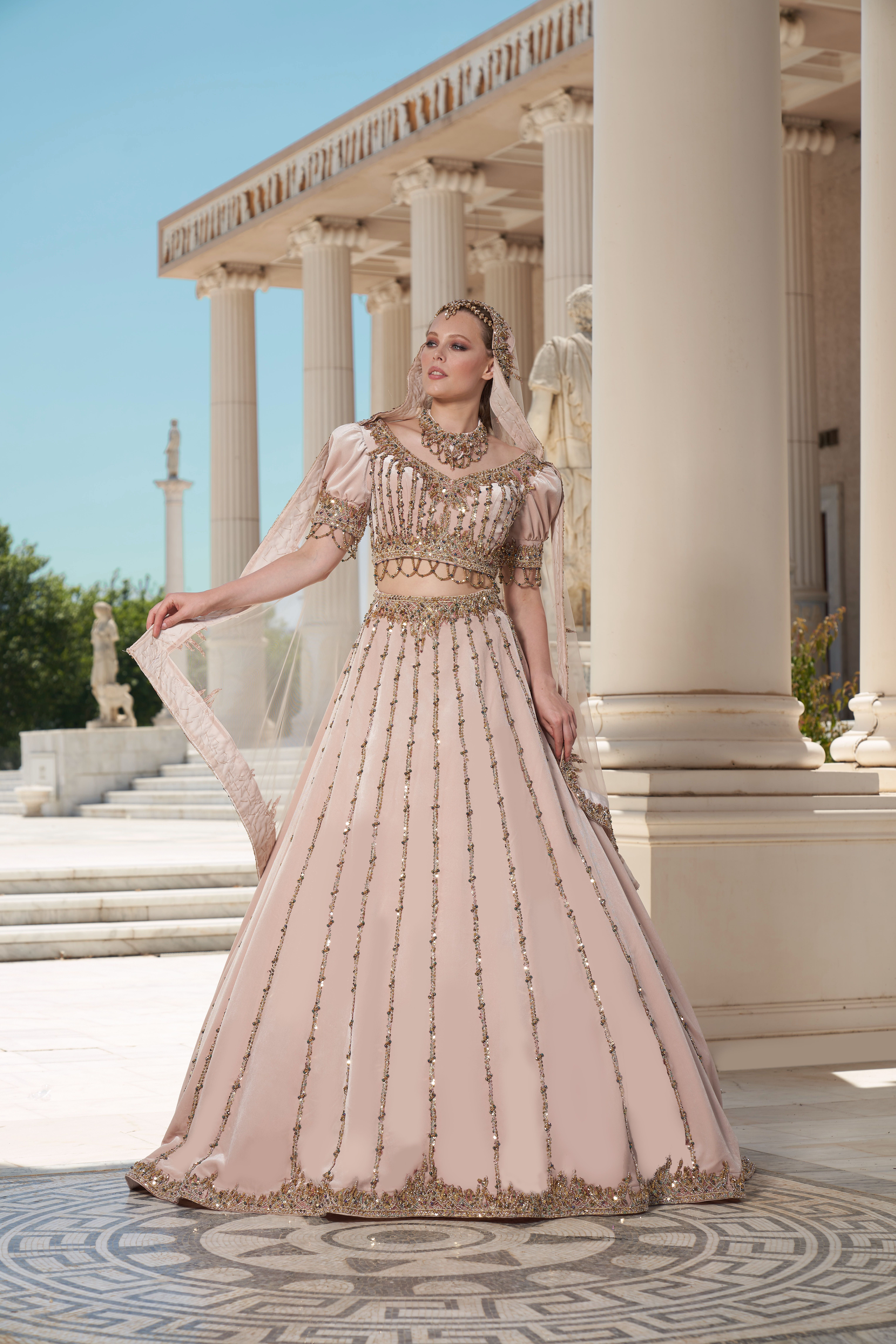 Elegant woman in a stylish dress poses at a historic landmark in Izmir, Turkey.