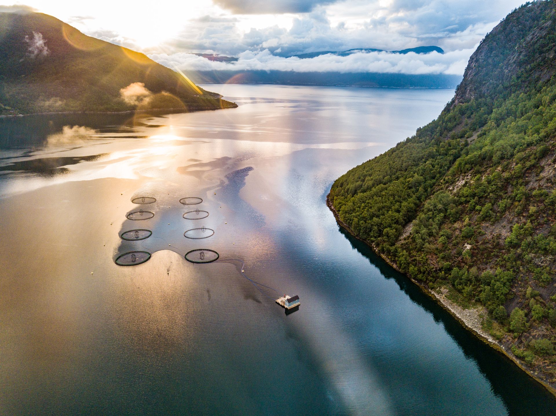 A stunning aerial view of a fish farm in Søreide, Norway captured at sunrise.