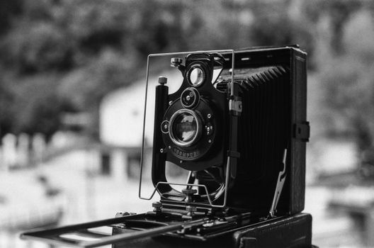 Close-up of a vintage camera in black and white, showcasing its intricate design and classic style.