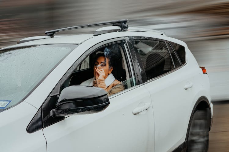 Woman Driving A Car And Smoking